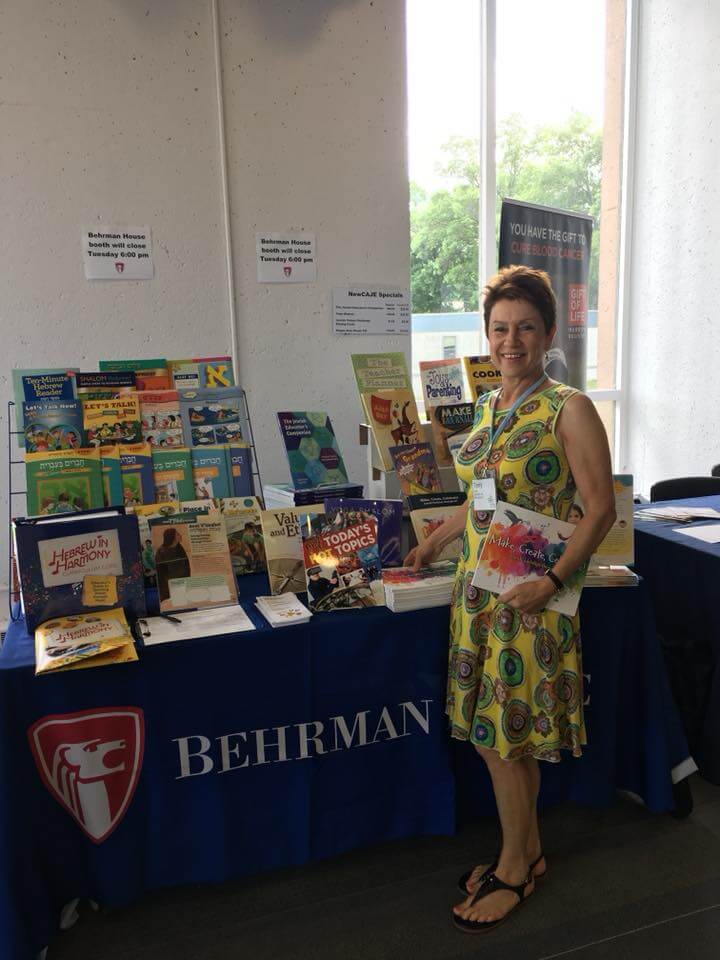 Woman standing by an exhibitor table of books