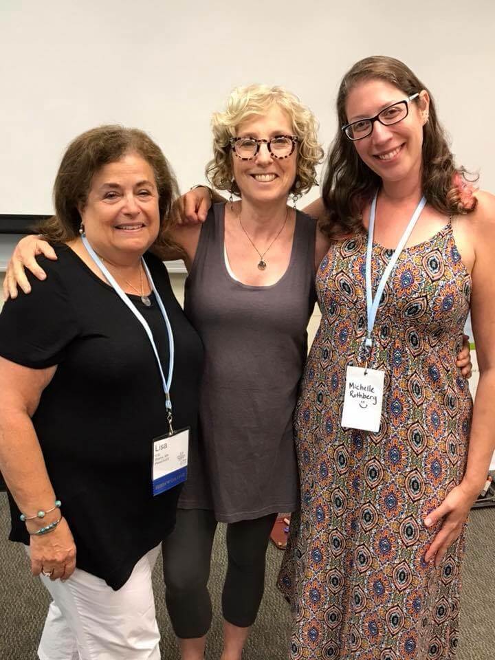 Three women posing with conference lanyards