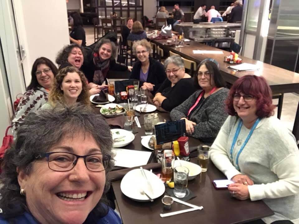 Educators smiling around a lunch table