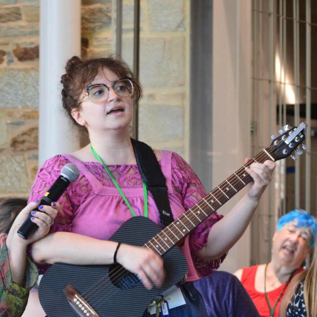 Woman singing and playing guitar