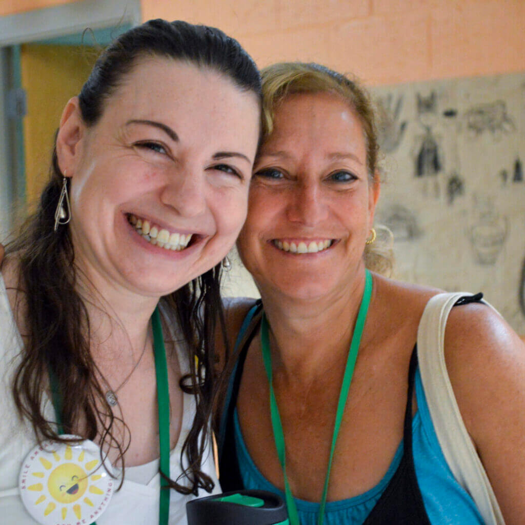 Two smiling women at a NewCAJE conference