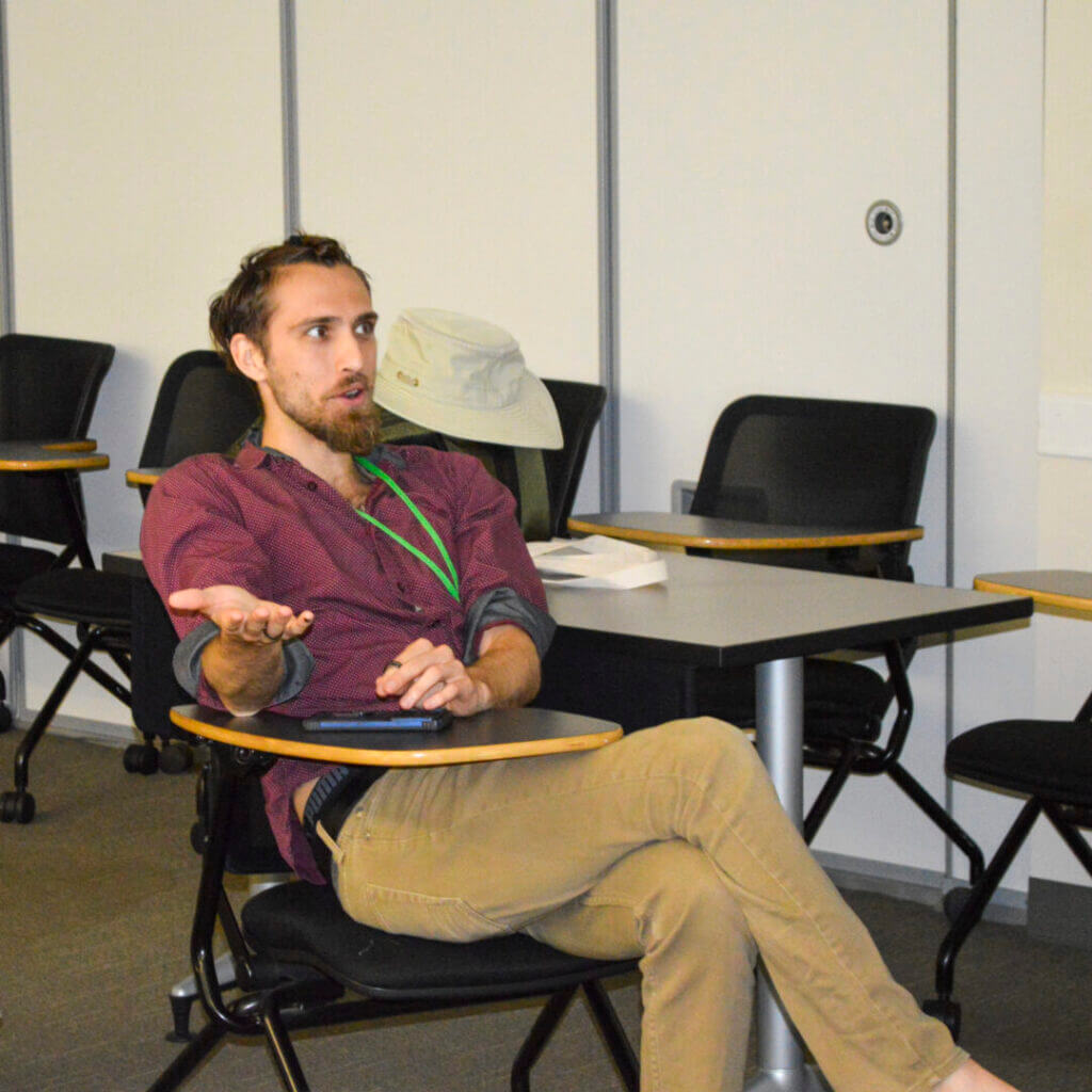 Man seated in a classroom during a session