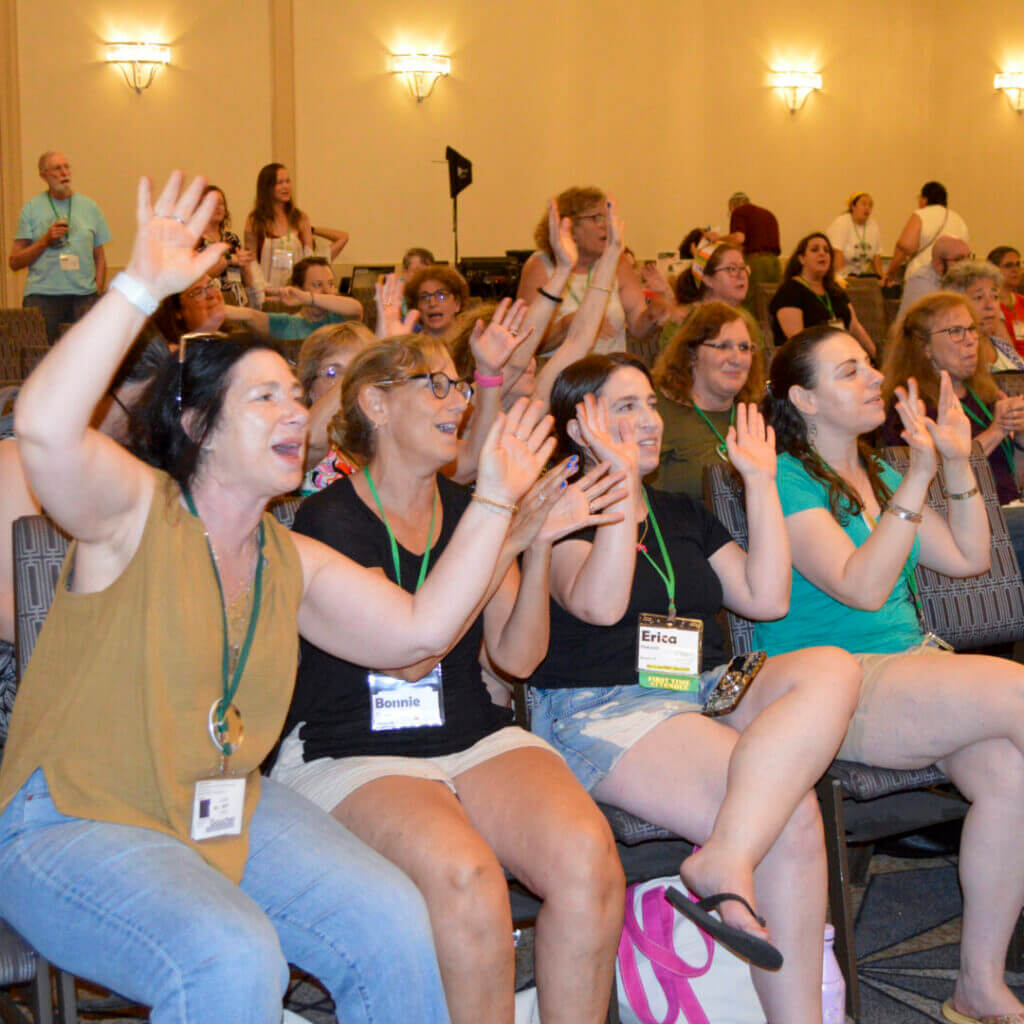 Excited audience raising hands during the raffle